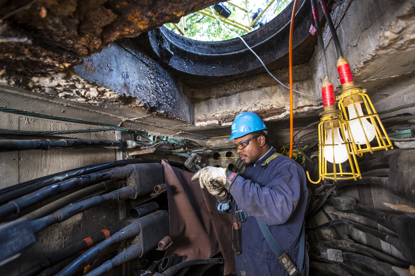 Utility technician working on underground cables beneath New York City